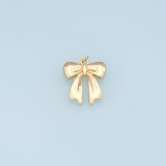 an image of a gold bow brooch on a light blue backgrounge background