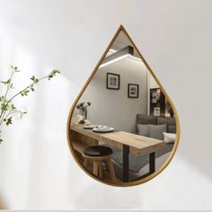 a mirror hanging on the wall reflecting a living room and dining area with a couch