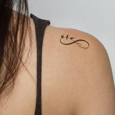 the back of a woman's shoulder with a tattoo on it that says love