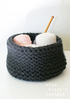 a knitted basket with two balls of yarn in it