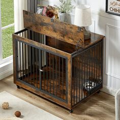 a dog crate sitting on top of a hard wood floor in front of a window