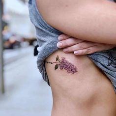 a woman with a tattoo on her stomach is looking down at the street while she's holding her arm over her shoulder