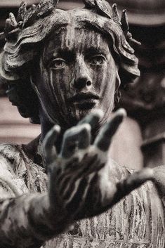 a black and white photo of a statue holding his hand out to the side with both hands