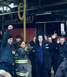 a group of people standing in front of a fire truck