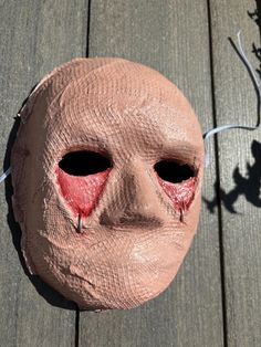 a mask that has been placed on a wooden surface