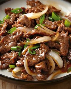 beef and onions in sauce on a plate