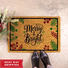 a person standing next to a merry and bright door mat