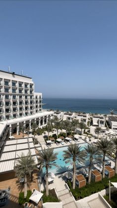 an aerial view of the resort and pool area with palm trees in front of it