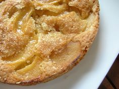 a close up of a pie on a white plate with wood table in the background