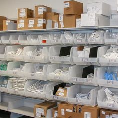 the shelves are filled with many different types of boxes and other items in plastic bins