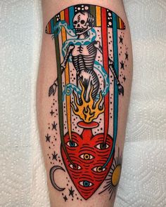 a person with a tattoo on their leg that has an image of a skeleton and fire