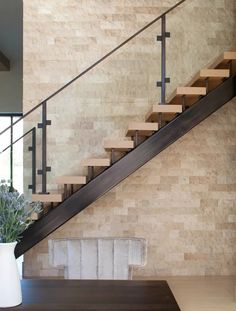 there is a vase with flowers on the table next to the stair case in this modern home