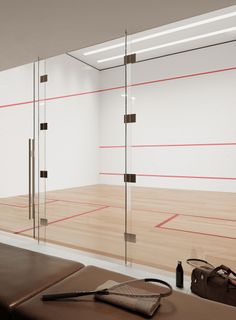 an empty room with wood flooring and glass partitions on the wall to let in light