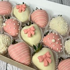 a box filled with pink and white chocolate covered strawberries