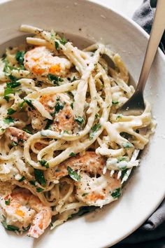 a white bowl filled with pasta and shrimp