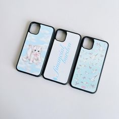 three iphone cases sitting next to each other on top of a white surface with birds and clouds