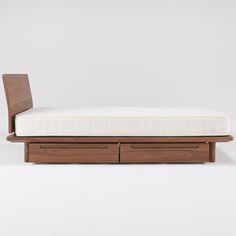 a bed with two drawers on the bottom and one drawer underneath it, in front of a white background