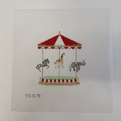 a cross stitch picture of a carousel with horses