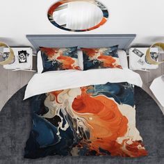 a bed with an orange, blue and white comforter