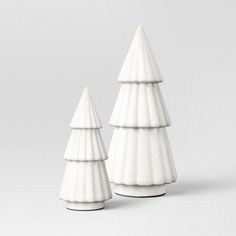 two white ceramic christmas trees sitting next to each other