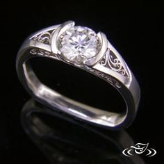 a diamond ring with filigrees on the sides