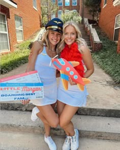 two women dressed in costumes pose for a photo on the steps outside their apartment building