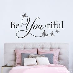 a bedroom with a bed and wall decal that says be you tiful