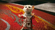 a small toy rat wearing a red and white sweater on top of a carpeted floor