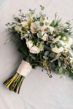 a bridal bouquet with white roses and greenery