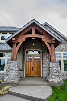 the front entrance to a house with stone and wood trimming on it's sides