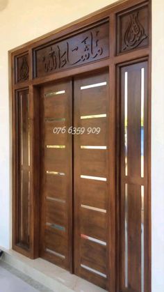 wooden door with arabic writing on the side and glass doors to both sides, in front of