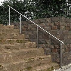 there is a stone wall next to the steps and railings that lead up to it