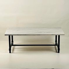 a marble coffee table with black metal legs on a white background in an empty room