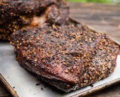 two pieces of steak on a tray with seasoning