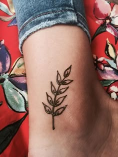 a woman's foot with a small tattoo on her left ankle, and a flower in the middle