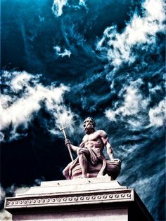 a statue on top of a building with clouds in the sky behind it and an image of a man holding a staff