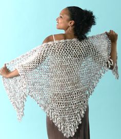 a woman wearing a white crochet shawl on top of a blue background