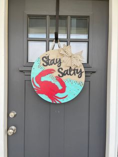 a door with a sign that says stay salty and a crab hanging from the side