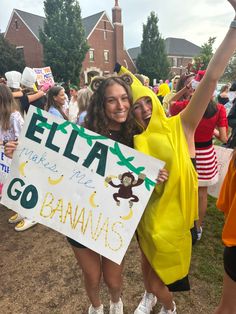 two girls in banana costumes holding up a sign