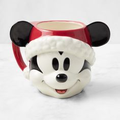 a mickey mouse mug with a santa hat on