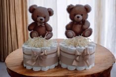 two teddy bears are sitting on top of the diaper cakes that have been made to look like baby shoes