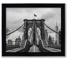 a black and white photo of the brooklyn bridge in new york city, with an american flag on top