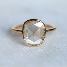 a close up of a ring with a faceted stone on it's side