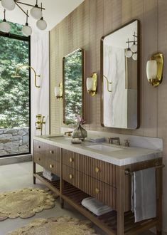 a bathroom with two sinks, mirrors and rugs