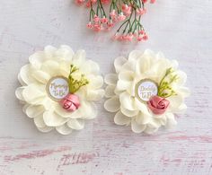 two white flowers with pink ribbons and some baby's breath written on the petals