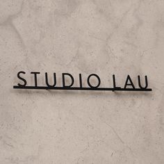 the word studio lau written in black on a white marble surface