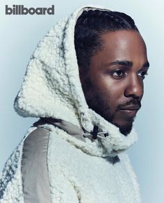 a man wearing a hooded jacket and looking off to the side with his hair in braids