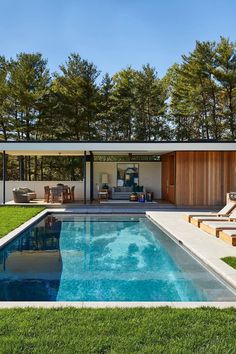 an outdoor swimming pool surrounded by grass and trees