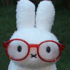 a white stuffed rabbit wearing red glasses