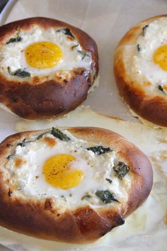 three baked eggs are on top of some bread